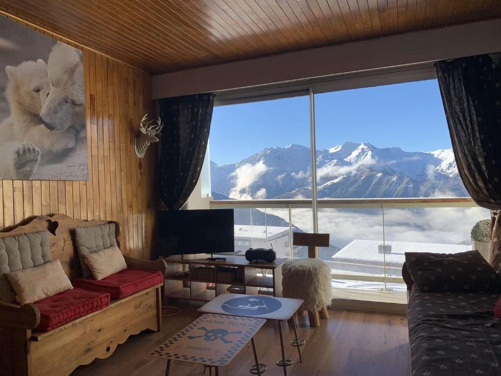 - un salon doté d'une grande fenêtre offrant une vue sur la montagne dans l'établissement Appartement cosy 2 pièces, 6 pers, balcon sud, Alpe d'Huez, proche remontées mécaniques et commerces - FR-1-405-162, à Huez