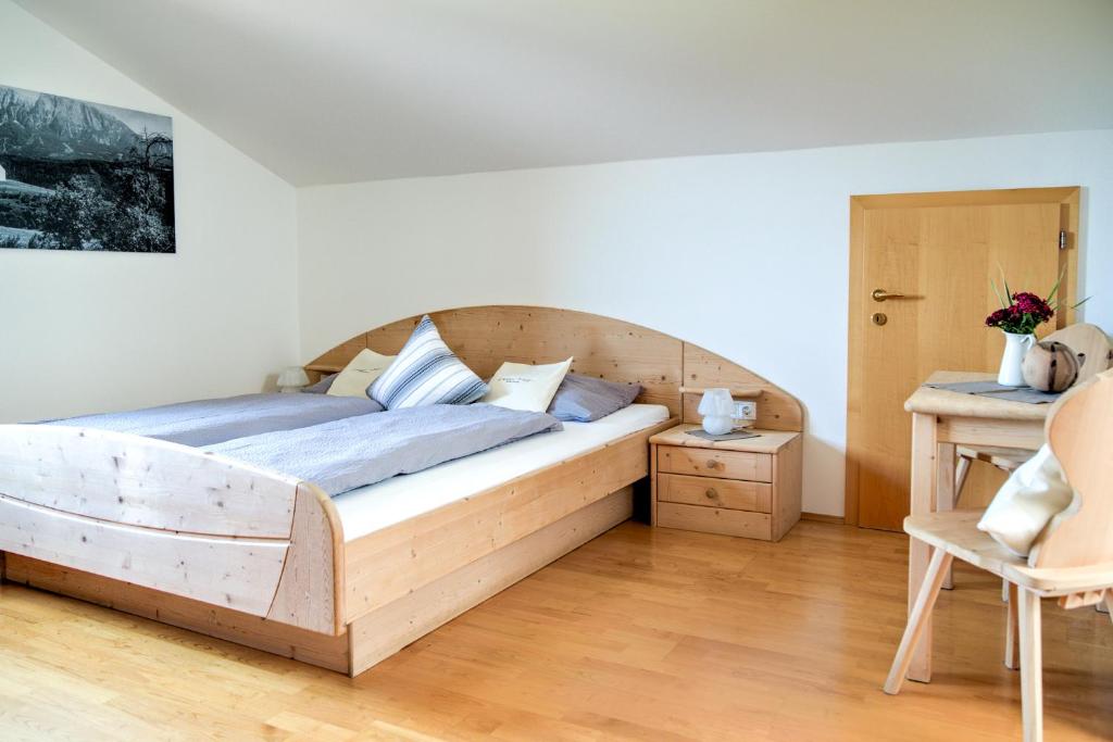 ein Schlafzimmer mit einem Holzbett und einem Stuhl in der Unterkunft Zunerhof Studio Fenn in Lengstein