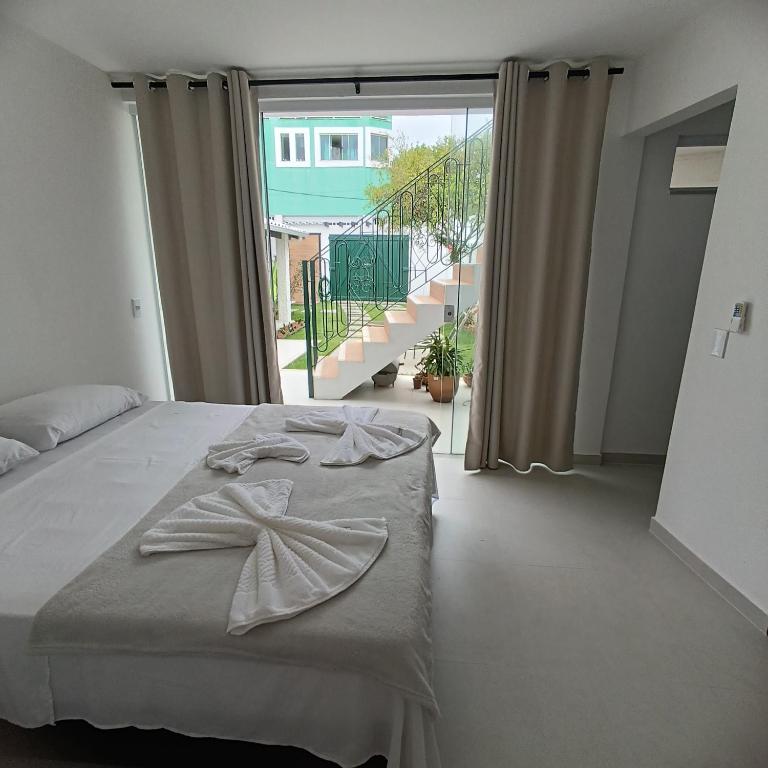 a bedroom with a bed and a large window at Ressurgência loft in Arraial do Cabo