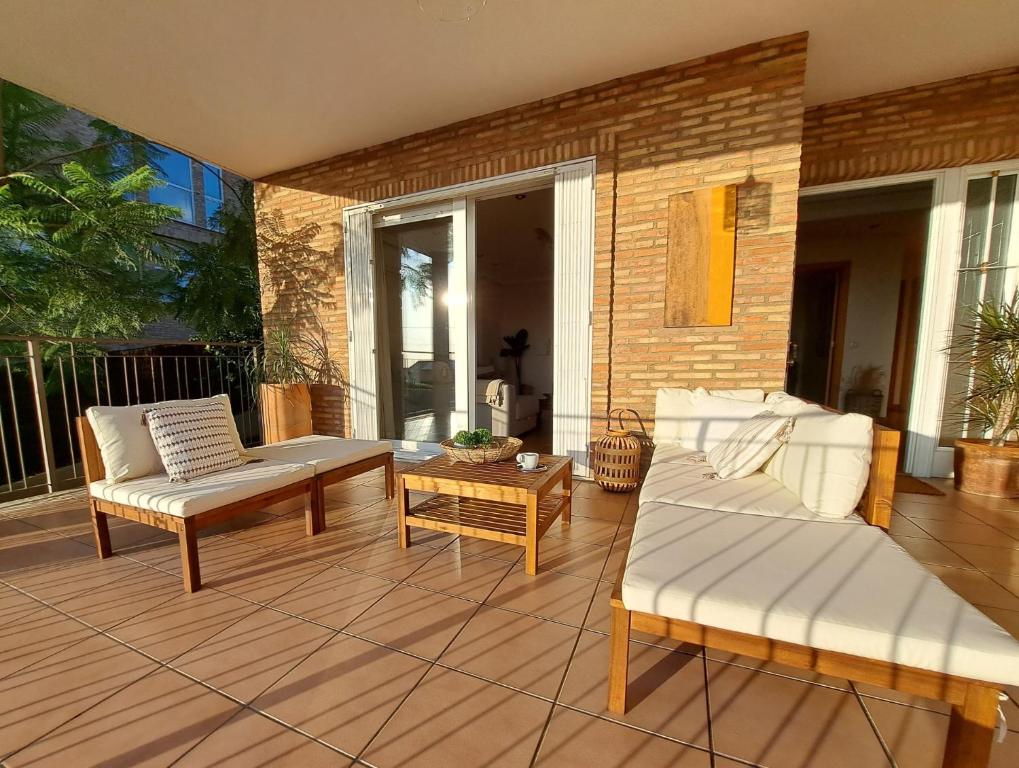 un patio con 2 sofás y una mesa de centro en Casa en Valencia, cerca de golf, playas, moto Gp, en Valencia