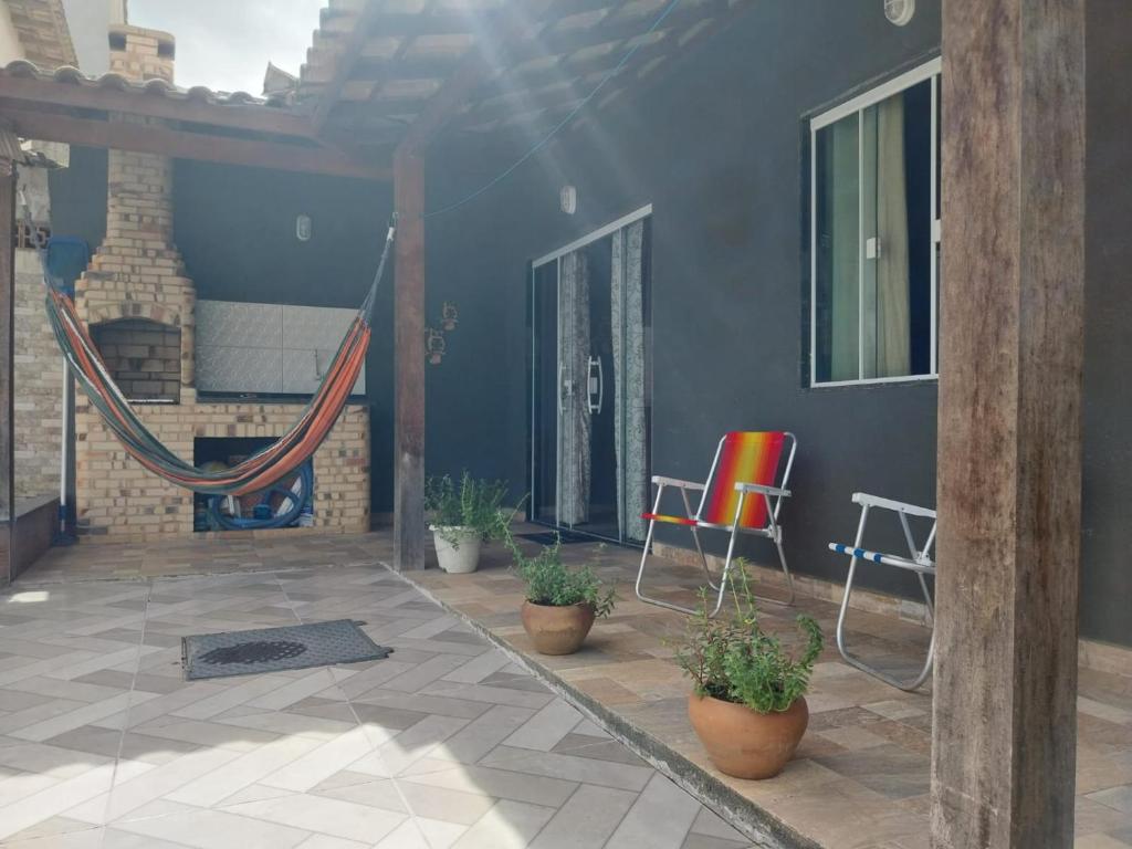 eine Terrasse mit Stühlen und Pflanzen in einem Haus in der Unterkunft Casa de praia em Unamar com piscina in Cabo Frio