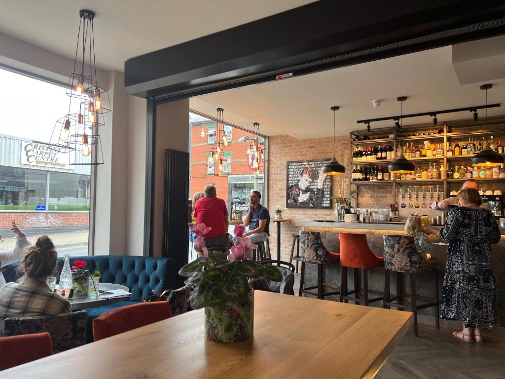 un grupo de personas sentadas en un bar en un restaurante en BOHOTEL en Macclesfield