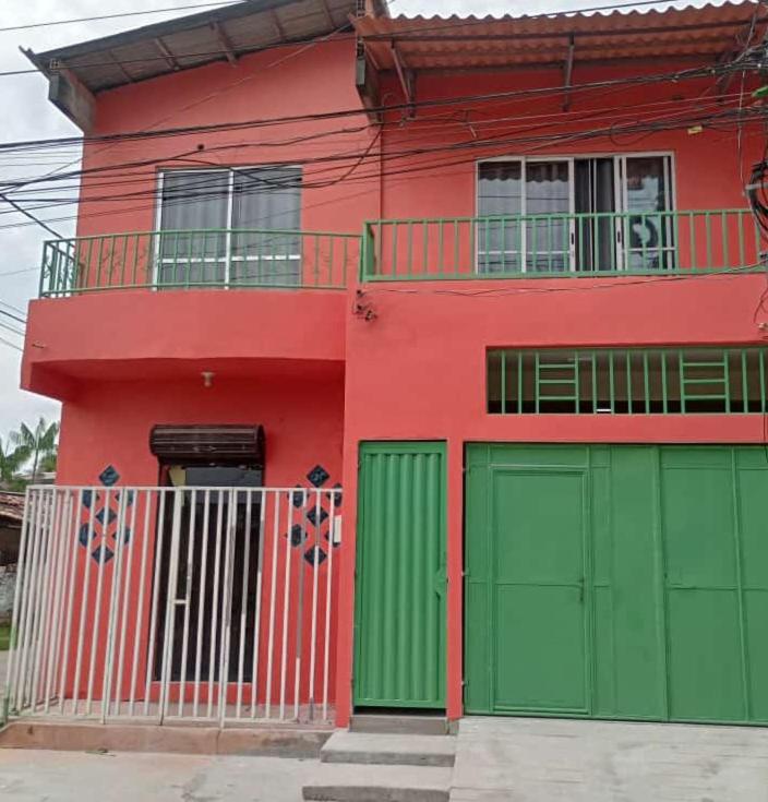 贝伦Casa da Deusa的红色绿色的房子,设有绿色的车库门