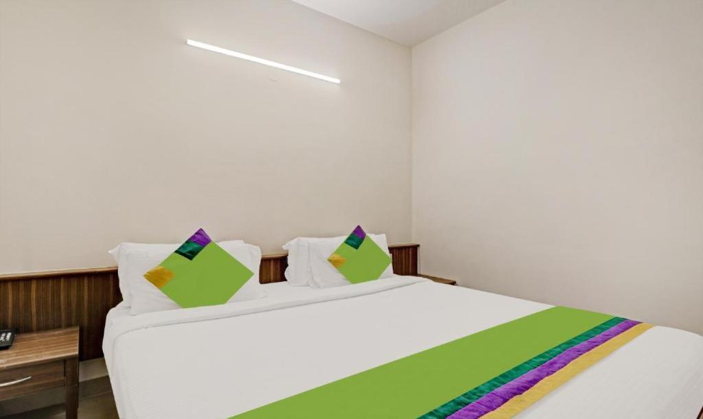 a bedroom with a large white bed with colorful pillows at Hotel Prime Pavilion-MG ROAD in Bangalore