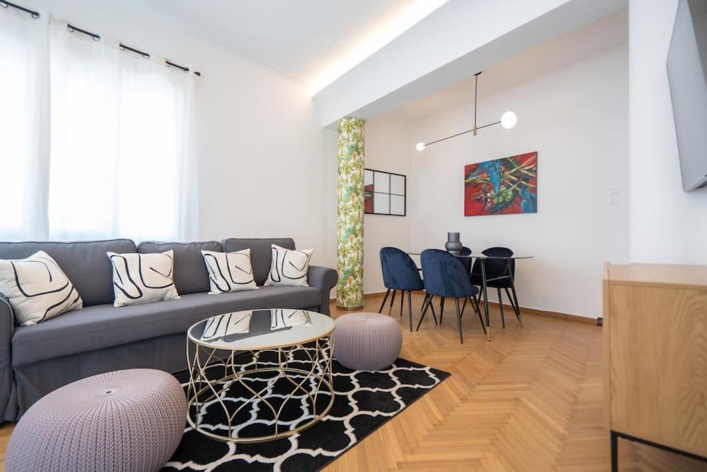 uma sala de estar com um sofá e uma mesa em Prime central location Athens, Big Balcony em Atenas