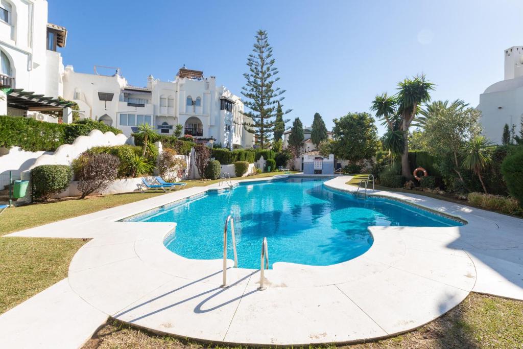 a swimming pool in a villa with trees and houses at El Zoco de Iñaki - Adults Only in Sitio de Calahonda