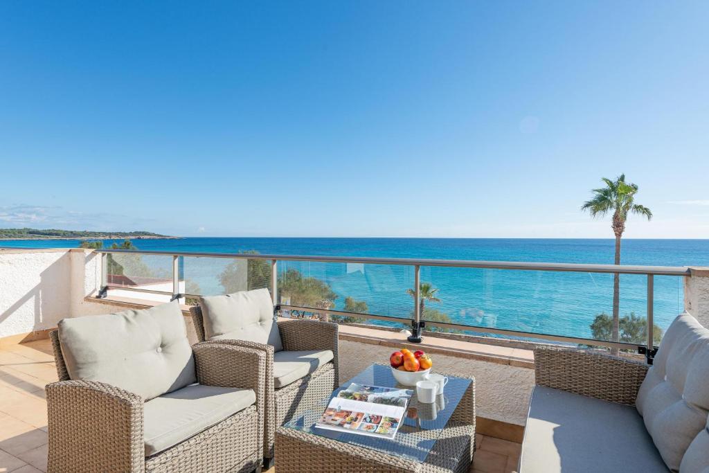 a balcony with chairs and a view of the ocean at Antic 201 in S'Illot