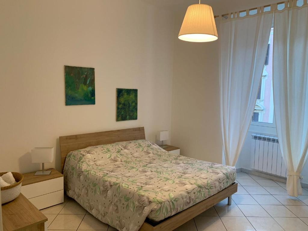 ein Schlafzimmer mit einem Bett, einer Lampe und einem Fenster in der Unterkunft Una finestra sul mare in Savona