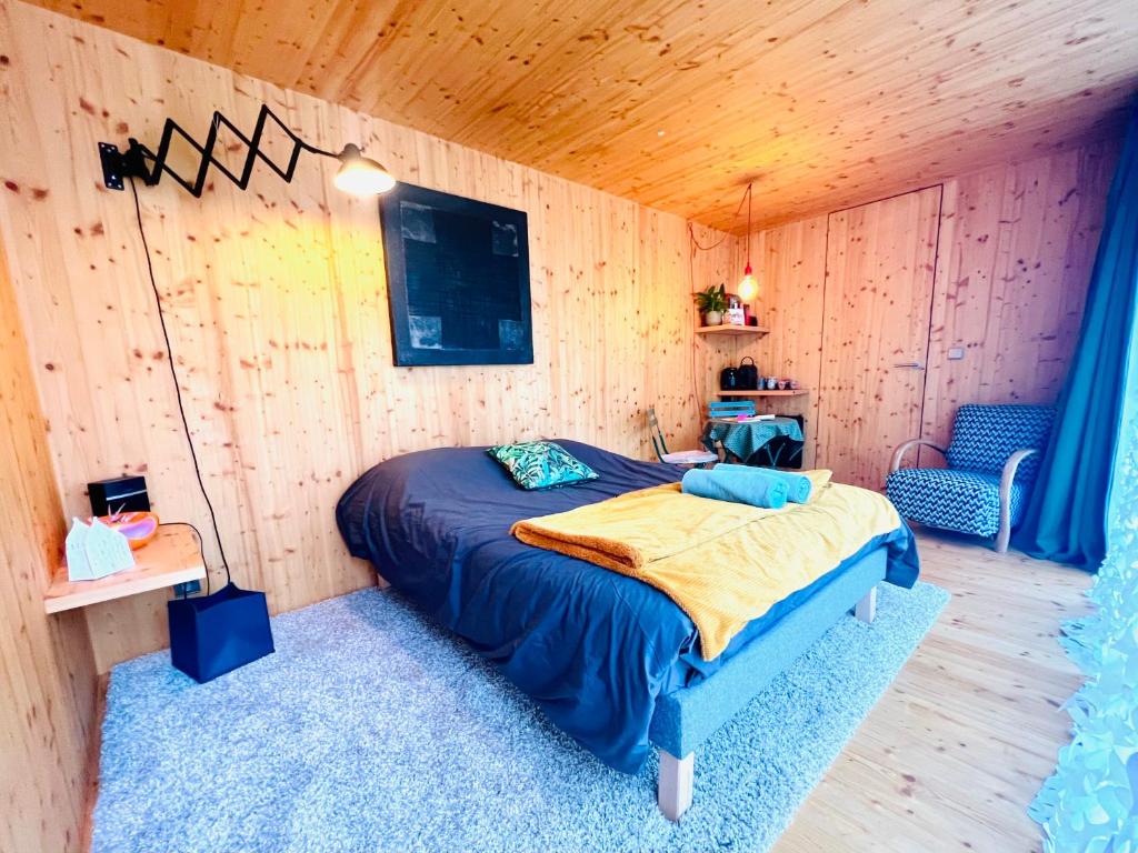 een slaapkamer met een bed in een houten kamer bij Luciz’ in Hunawihr