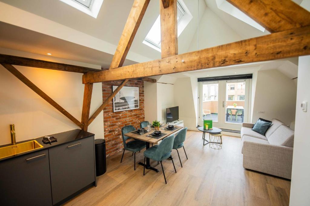 een keuken en een woonkamer met een tafel en stoelen bij Spectacular 70m2 Penthouse with Terrace in Eindhoven