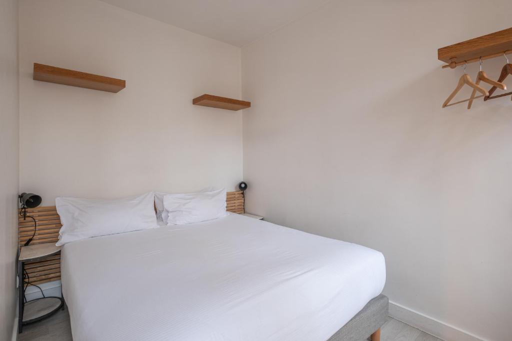 パリにあるレジデンス クリニャンクールのベッドルーム1室(白いベッド1台付)