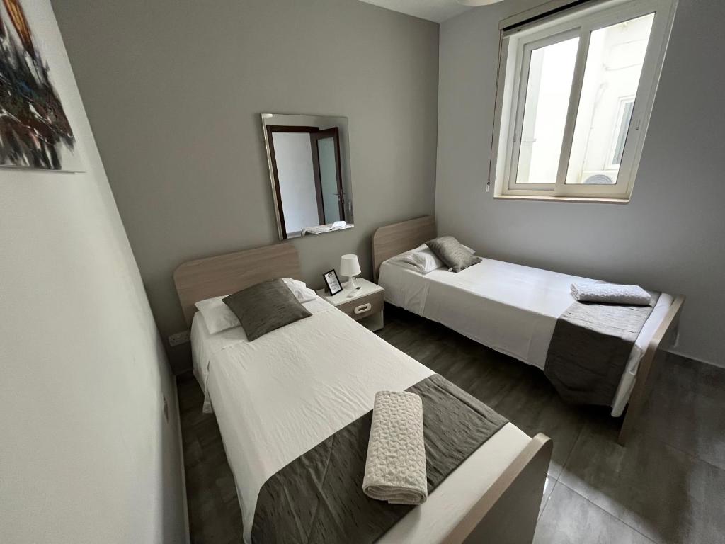 1 Schlafzimmer mit 2 Betten und einem Fenster in der Unterkunft F8-2 Room 2 single beds shared bathroom in shared Flat in Msida
