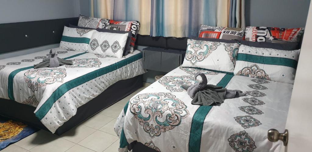 um quarto com 2 camas com edredão e almofadas em 1403 on 10 South Beach em Durban