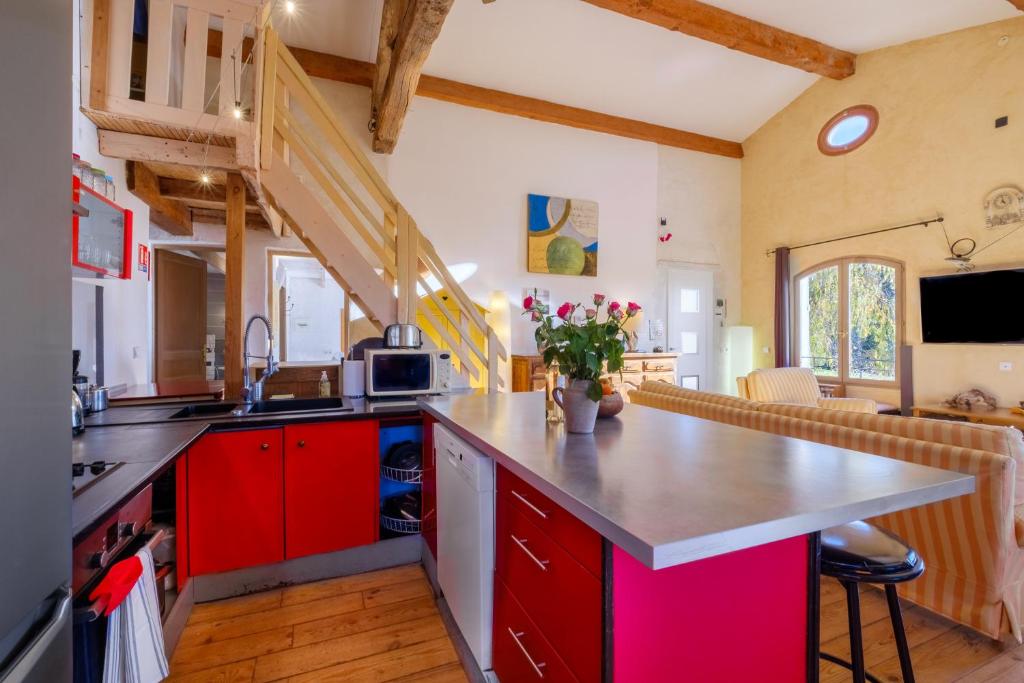 a kitchen with red cabinets and a counter top at Villa Provence Vue Panoramique - in Fayence
