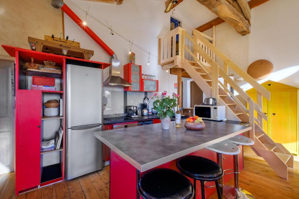 a kitchen with red cabinets and a counter with stools at Villa Provence Vue Panoramique - in Fayence