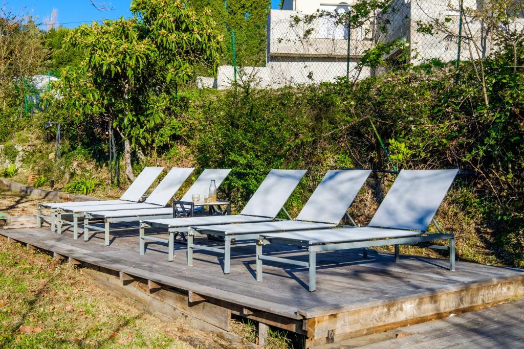 a row of lounge chairs sitting on a wooden deck at Villa Provence Vue Panoramique - in Fayence