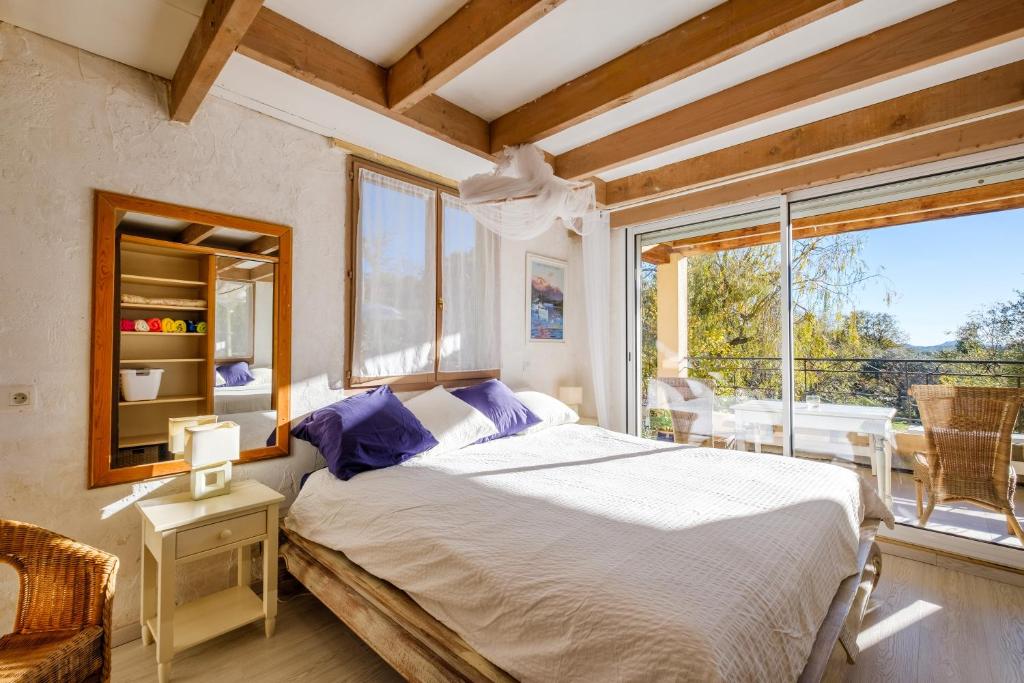 a bedroom with a bed and a large window at Villa Provence Vue Panoramique in Fayence