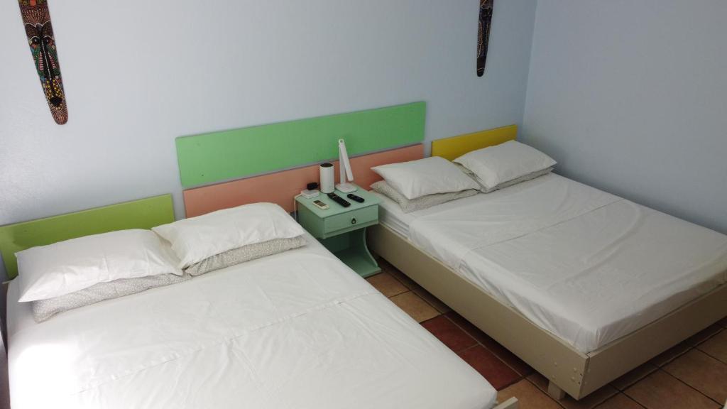 dos camas sentadas una al lado de la otra en una habitación en Bohemian Monkey, en Cahuita