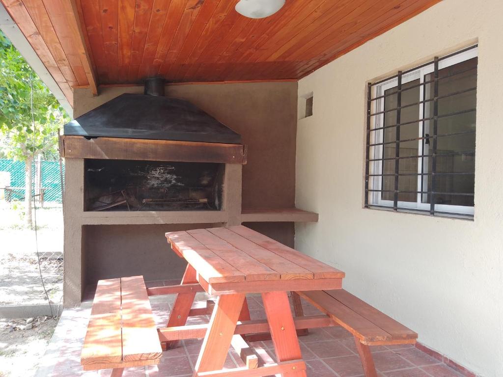a picnic table and a grill with a picnic bench at Cabañas Eluney in Villa Parque Siquiman