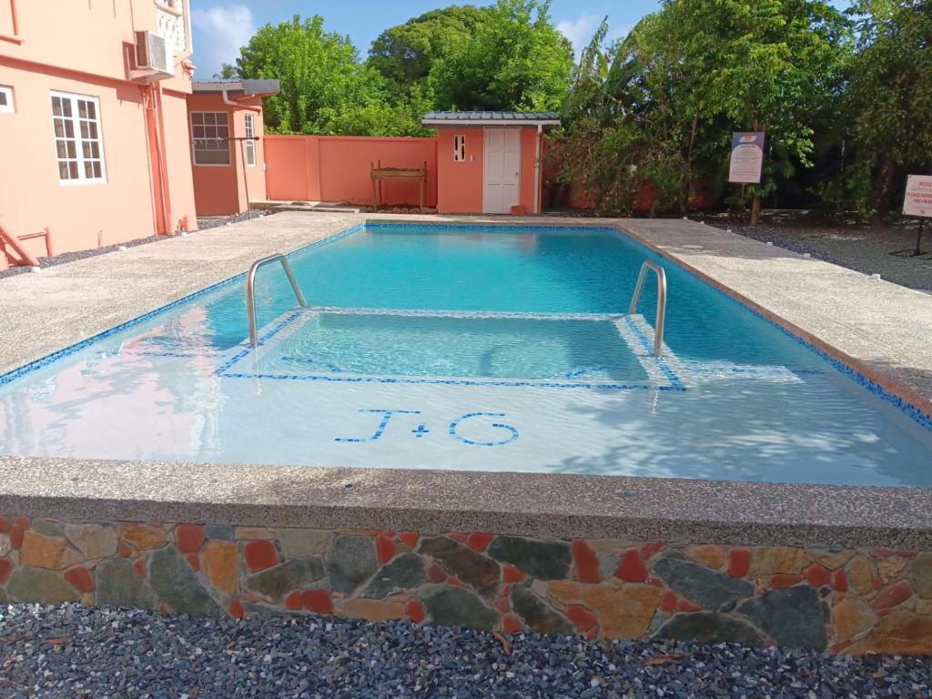 una piscina con un reloj en el medio en JGs Tropical Apartments, en Crown Point