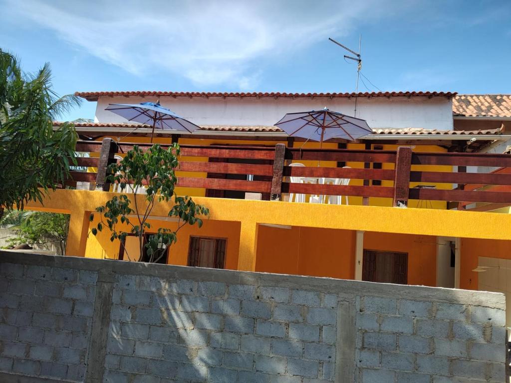 a house with a yellow fence in front of it at Sobrado dos Pássaros in Arraial do Cabo