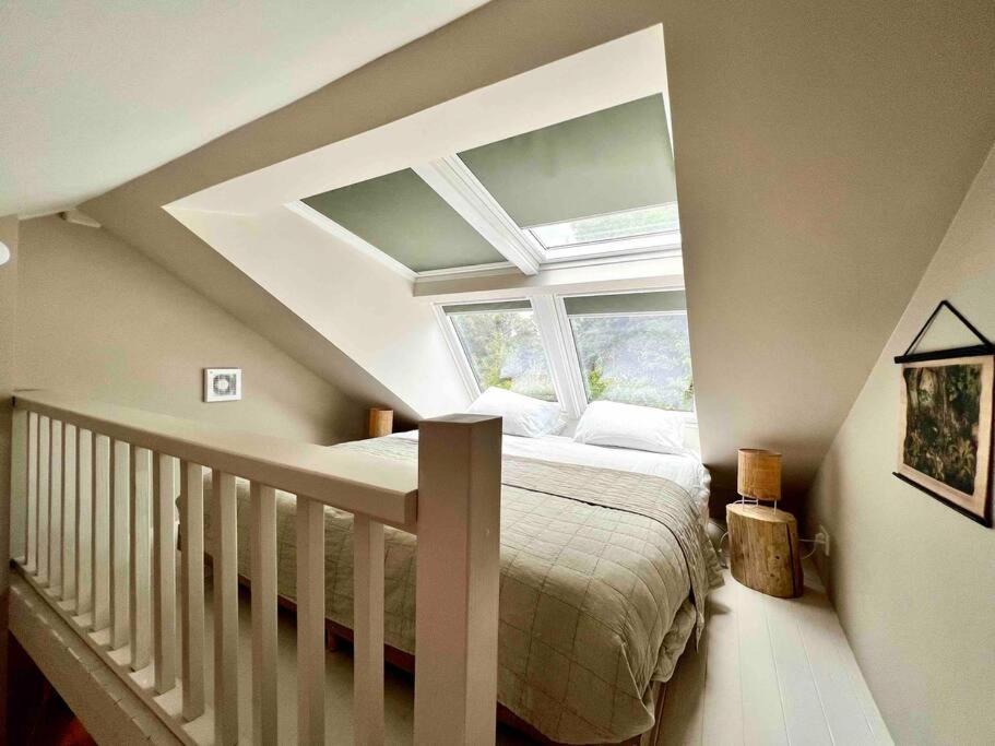 een slaapkamer op zolder met een bed en een raam bij Duynbossie in Schoorl