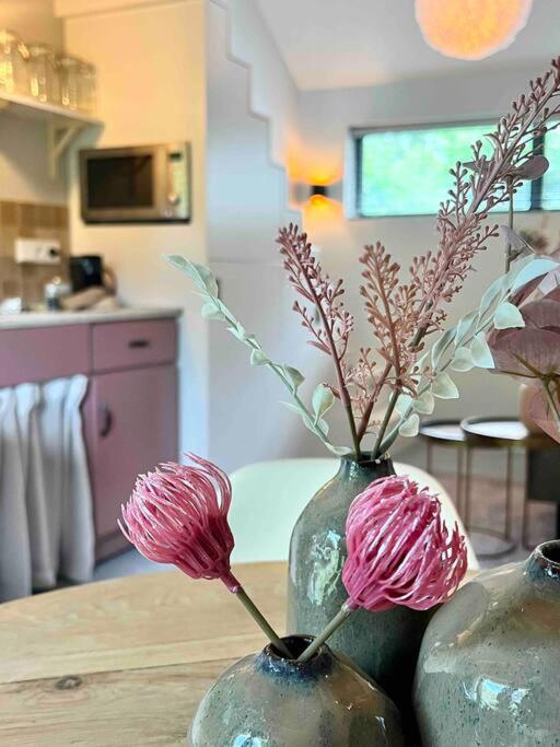 two vases with flowers in them on a table at Duynbossie in Schoorl