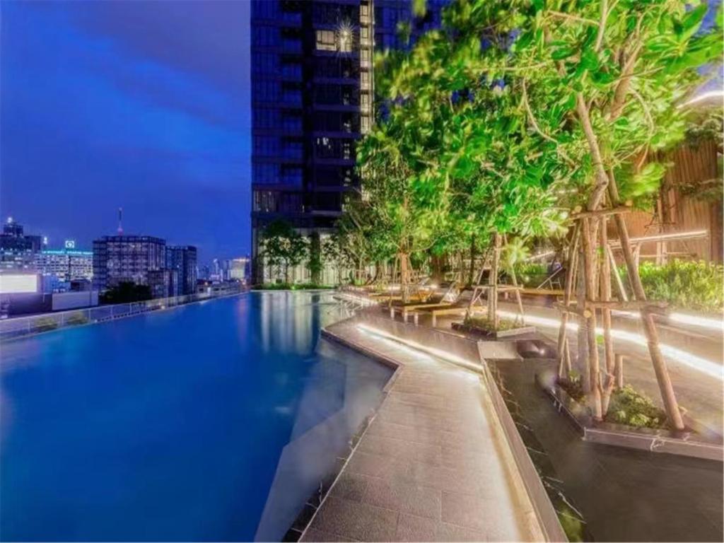a large swimming pool with trees in a city at 免费接机/空中楼阁/水果西施夜市/热带雨林/RCA/无边泳池/近地铁Rama9 in Bangkok