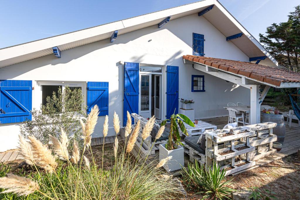 une maison avec des portes bleues et une terrasse dans l'établissement Vieux Boucau Maison Avec Jardin, à Vieux-Boucau-les-Bains