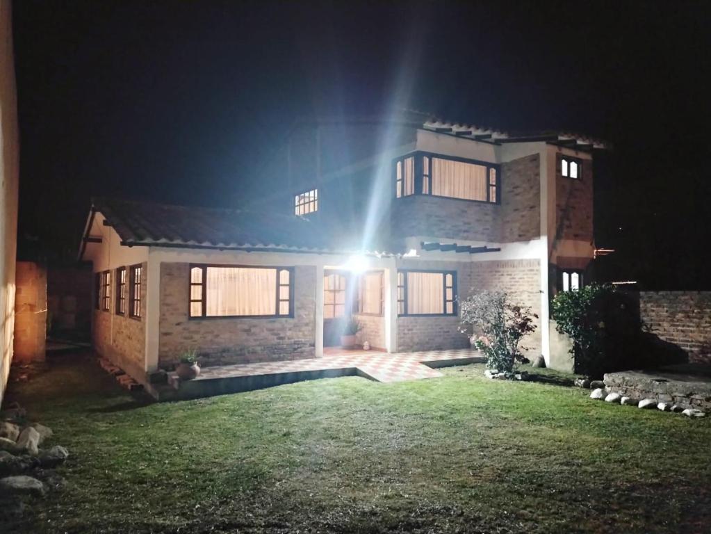 a house lit up at night with a spotlight at El Rincon de Quevedo in Sáchica