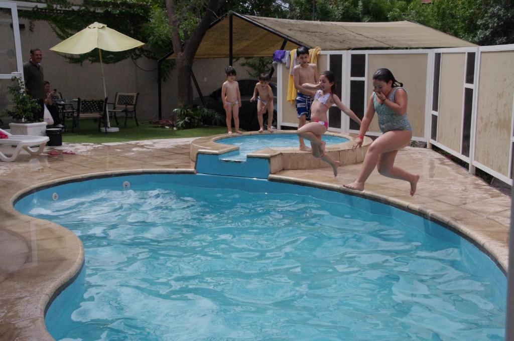 un grupo de personas jugando en una piscina en Terrabella Apart en Mendoza