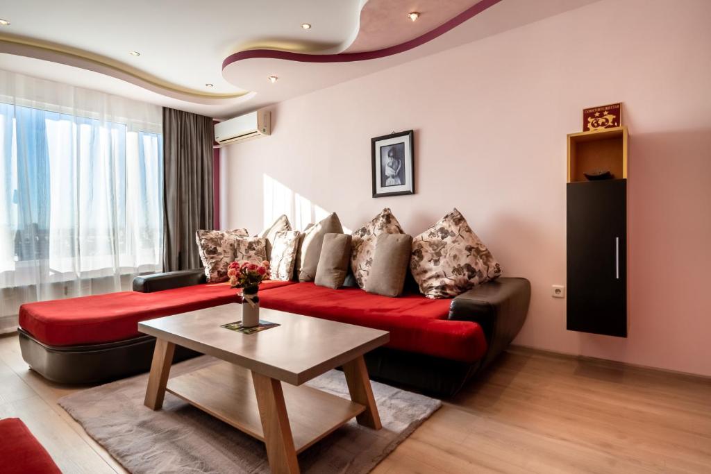 a living room with a red couch and a table at Apartments Rosina in Plovdiv