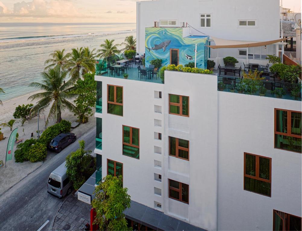 a white building with a painting on it next to the beach at h78 in Hulhumale