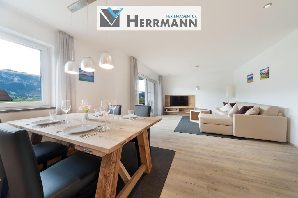 a dining room with a table and a living room at Landhaus am See Appartement LH 03 in Schwangau