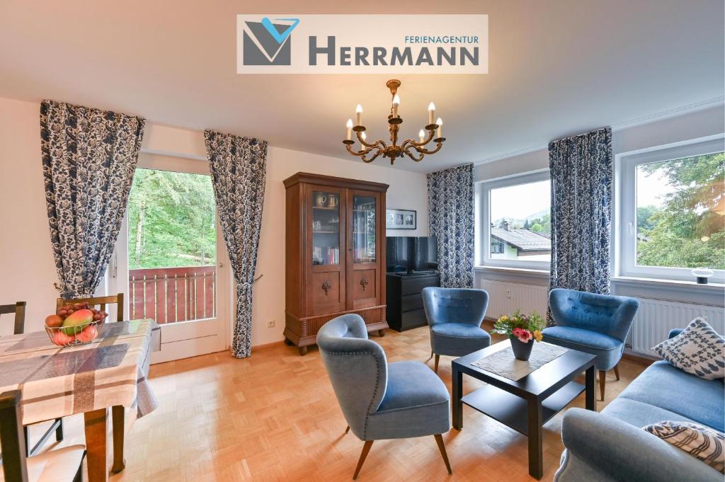 a living room with a dining room table and blue chairs at Ferienwohnung Landhaus Helga unterm Schloss in Schwangau