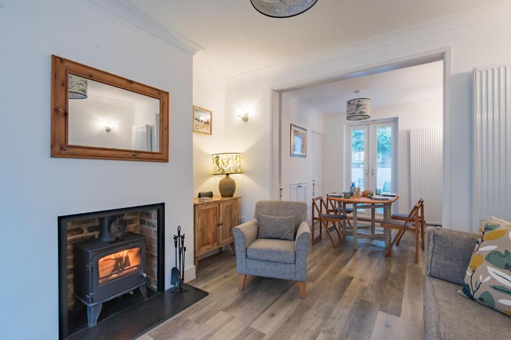 a living room with a fireplace and a table at Samphire Cottage by Bloom Stays in Broadstairs