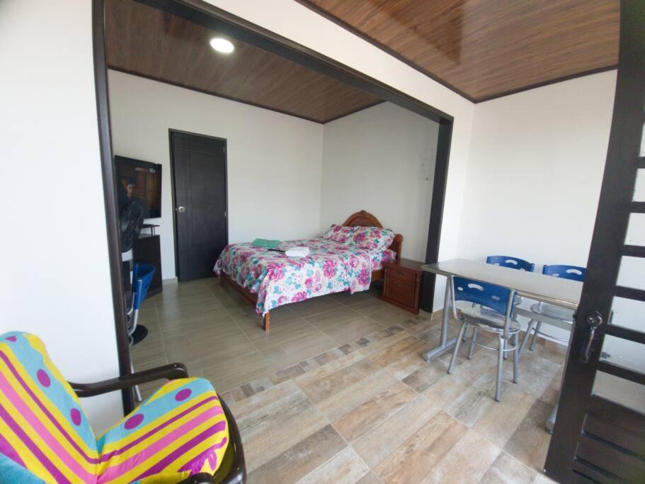 a bedroom with a bed and a table and chairs at Apto-baño privado y área de trabajo para ti solo in Acacías