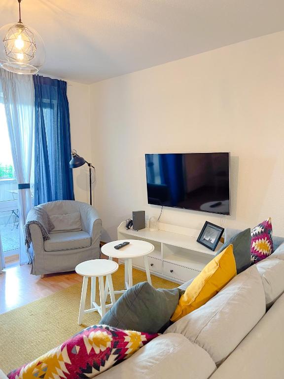 uma sala de estar com um sofá e uma televisão de ecrã plano em 2 Zimmer City Apartment mit Terrasse und Tiefgaragenstellplatz in Zentrum von Leipzig em Leipzig