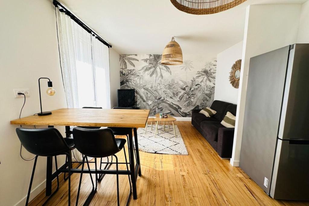 een keuken en een woonkamer met een tafel en stoelen bij Appartement cosy - centre-ville in Lorient