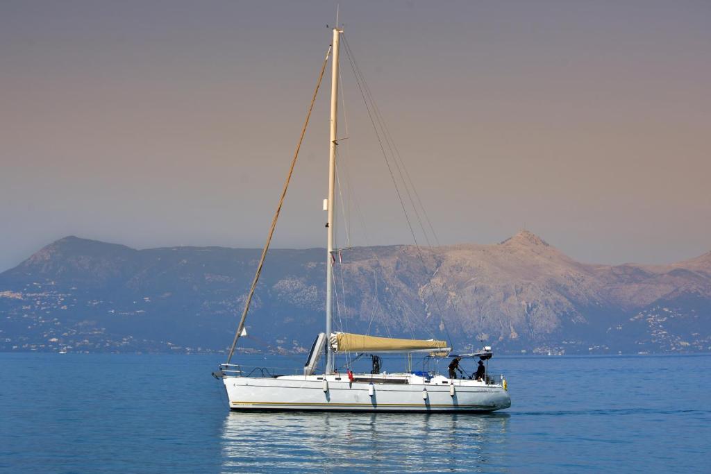 a white sailboat on the water with mountains in the background at Sun odyssey 43ia in Corfu Town