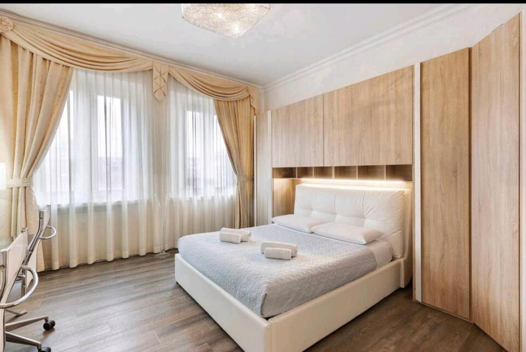 una camera da letto con un grande letto bianco e una finestra di Residenza Tosca a Mantova