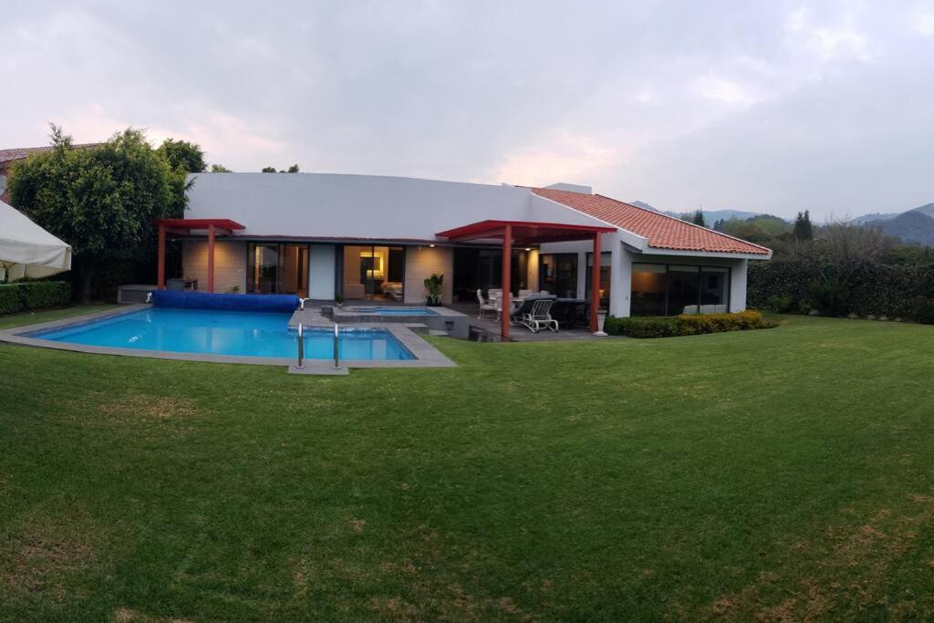 une maison avec une piscine dans une cour dans l'établissement CASA MOSHI, à Malinalco