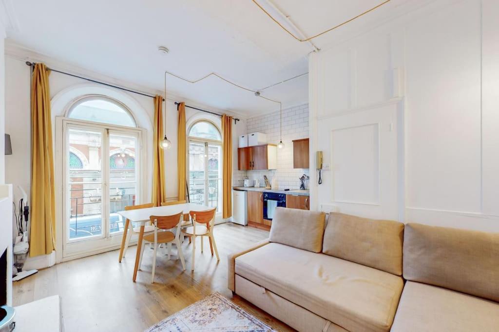 a living room with a couch and a table at Modern 2 Bed Maisonette in Farringdon Barbican in London