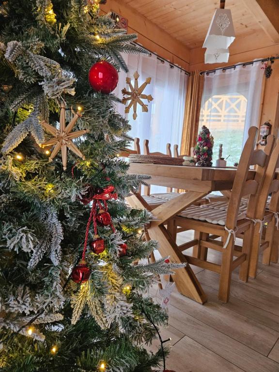 a christmas tree in a room with a table and chairs at Góralska Chatka 2 Highland Cottage - Split AC, Jacuzzi, Sauna, Private parking, Mountains View, Garden, Zakopane in Zakopane