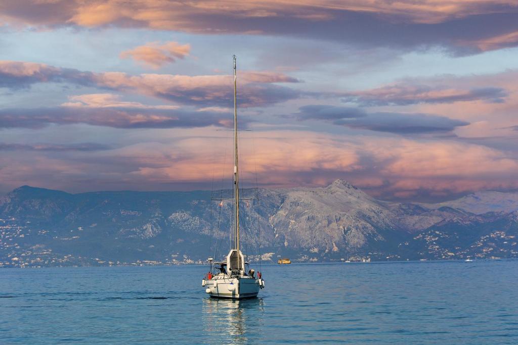 a boat in the water with a mountain in the background at S Odyssey 35243ib in Corfu Town