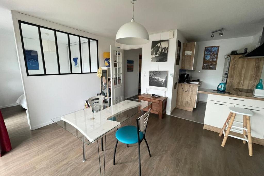 eine Küche mit einem Glastisch und 2 Stühlen in der Unterkunft Studio récent Cosy - Ploemeur in Ploemeur