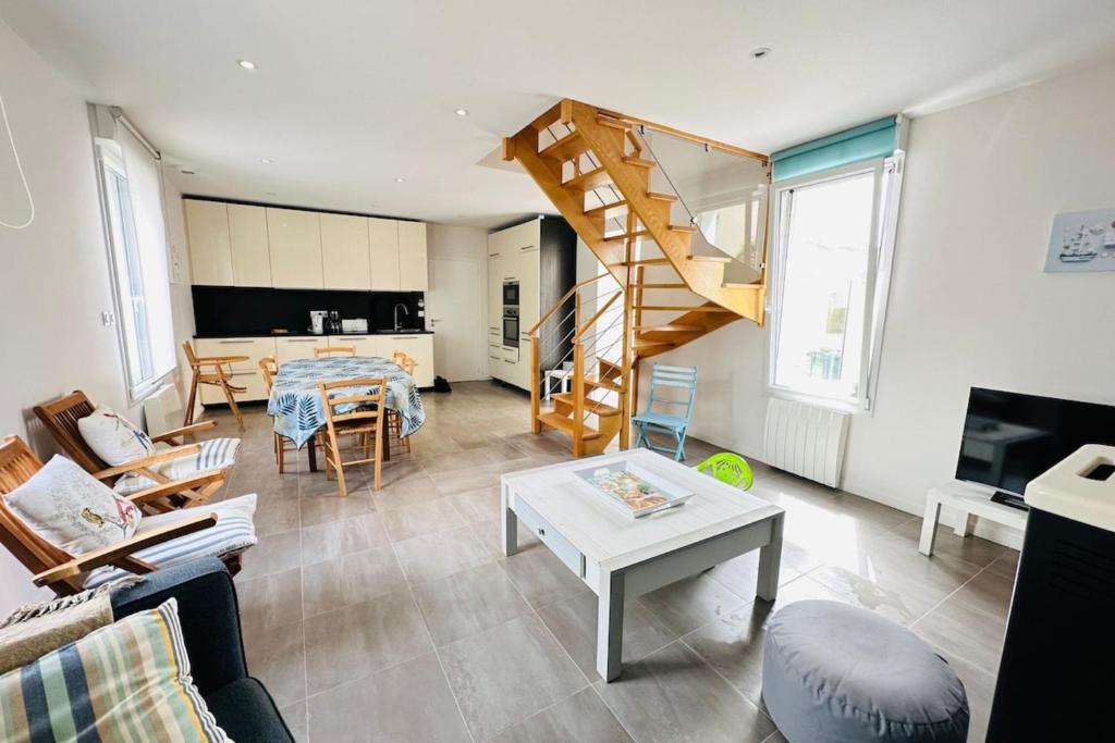 ein Wohnzimmer mit einer Treppe und einem Tisch in der Unterkunft Jolie maison de pêcheur - Mer in Riantec