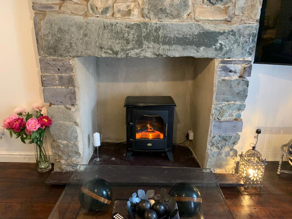 a stone fireplace with a stove in a living room at One Bedroom Apartment in Bethesda in Bangor