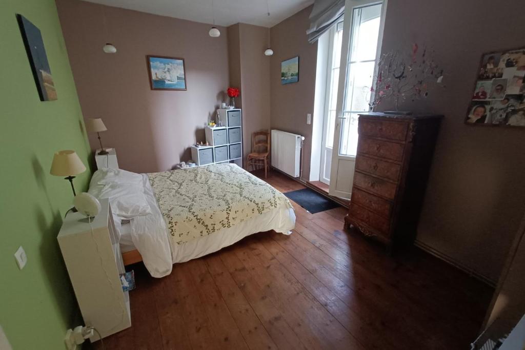 um quarto com uma cama, uma cómoda e uma janela em Chambre Fécamp em Fécamp