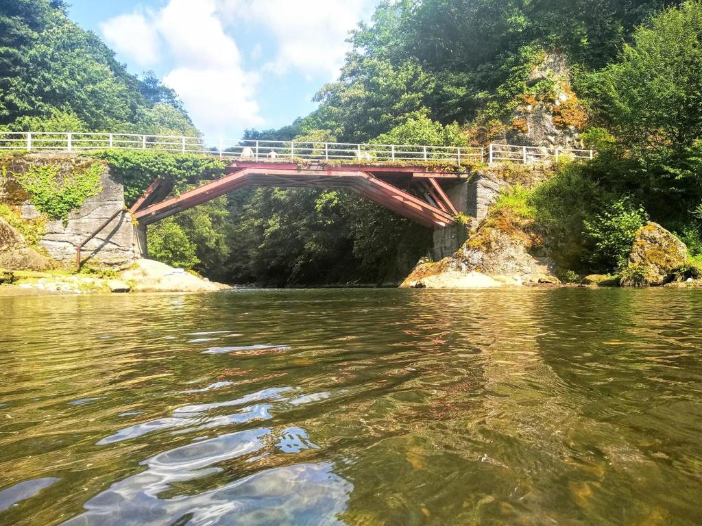 eine Brücke über einen Fluss mit dem Wasser in der Unterkunft bukistsikhe in Chʼokhatauri